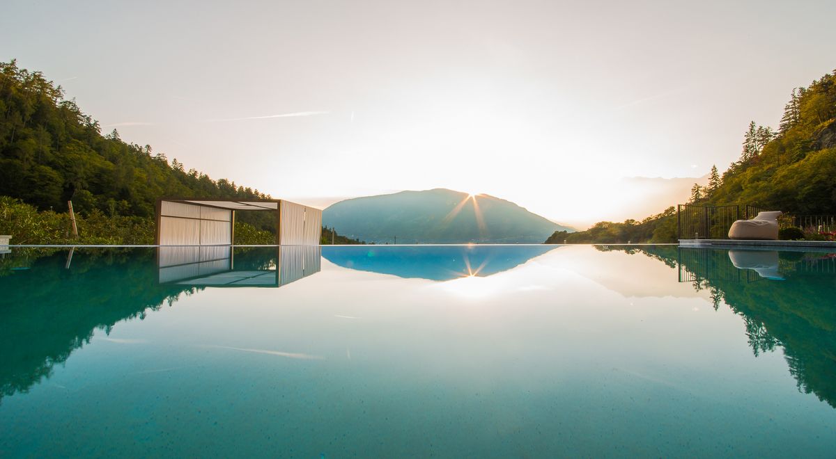 Sonnenuntergang über Infinity Pool in Südtirol im Wellnesshotel Kiendl Schenna bei Meran
